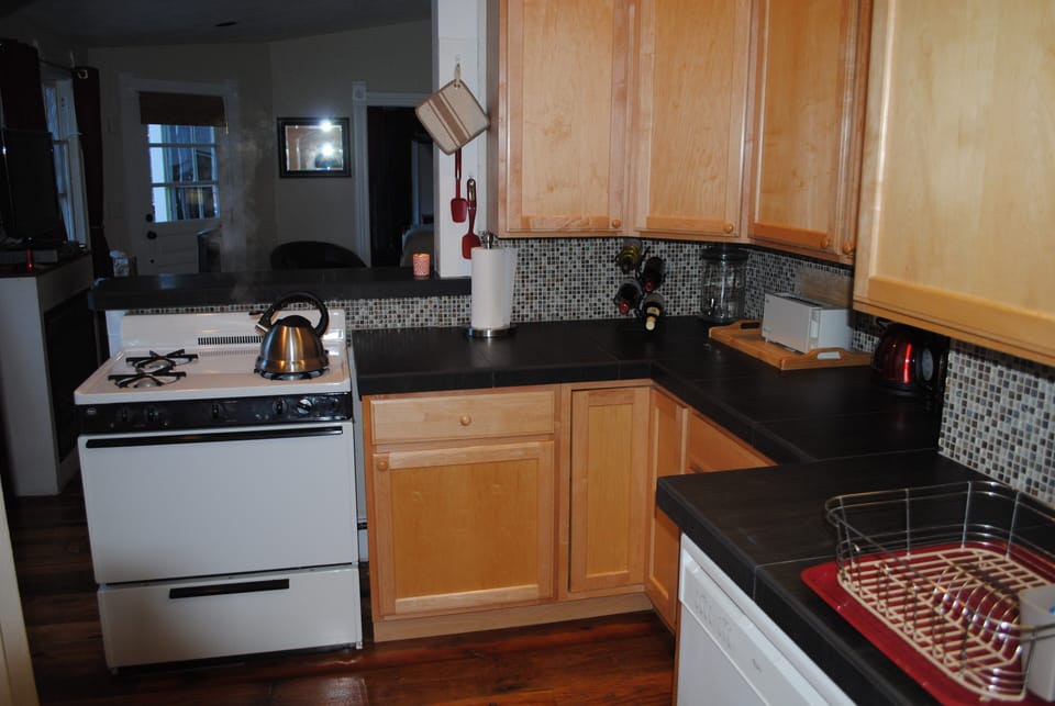The kitchen adjoins the living room with comfortable sofa and high top table 