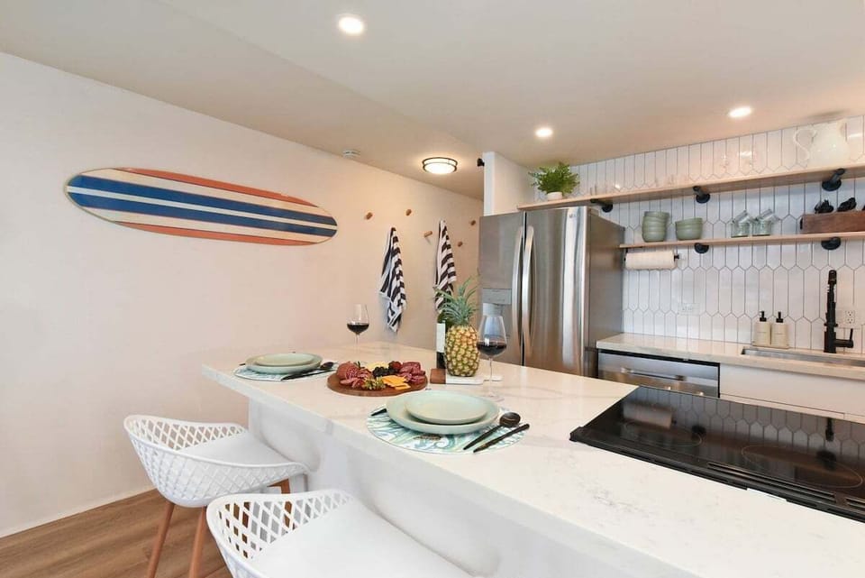 Modern kitchen with bar seating and beachy touches, perfect for sipping coffee and planning adventures