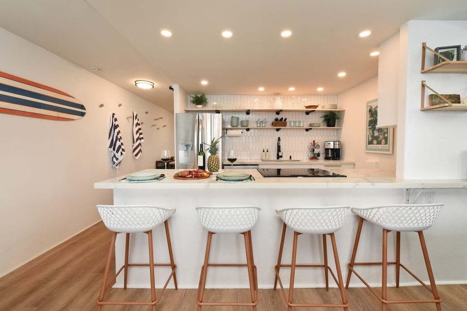 Spacious kitchen with surfboard decor and bar seating, perfect for casual breakfasts and beach vibes