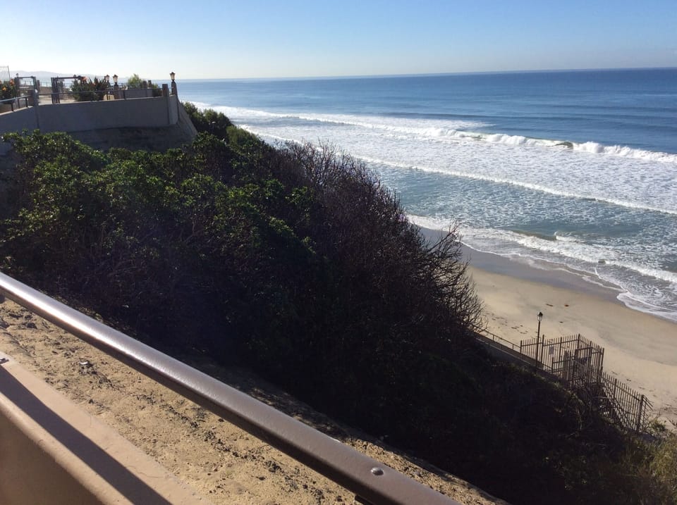 Staircase from pool area down to sandy beach