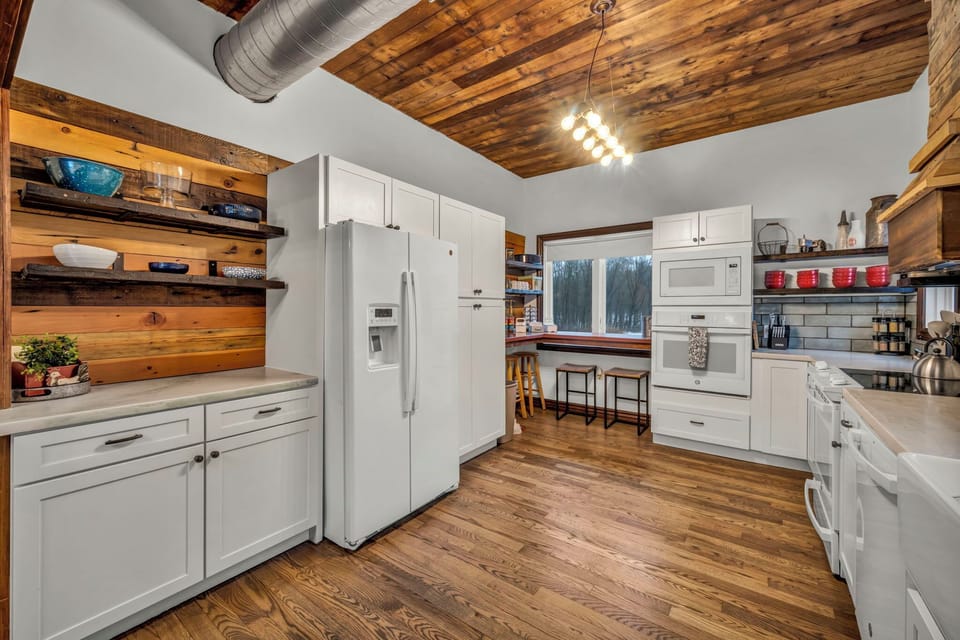 Newly renovated kitchen with modern appliances, double ovens, and open flow to the living area. Features coffee/tea bar, Instant Pot, crock pot, griddle, blender, and more, perfectly equipped for any group gathering. Just ask, we likely have it!