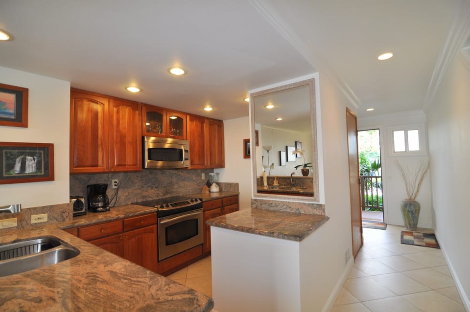Fully equipped kitchen area - electric range, built-in microwave & dishwasher.