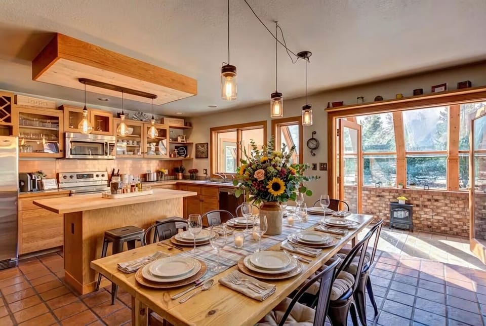 Kitchen–Sunroom Flow — The country kitchen opens into the sunroom—anchored by a harvest table that keeps everyone together from breakfast to bedtime. 🍽️🌞