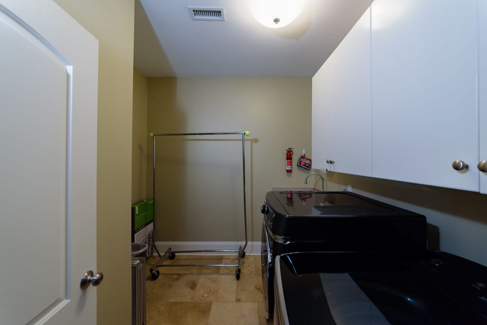 2nd floor laundry has high capacity washer, & dryer, sink, ironing board & iron.