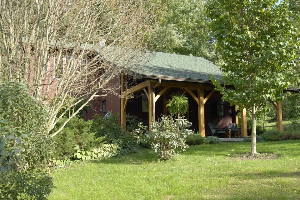 Covered post and beam porch overlooks 1 acre yard.