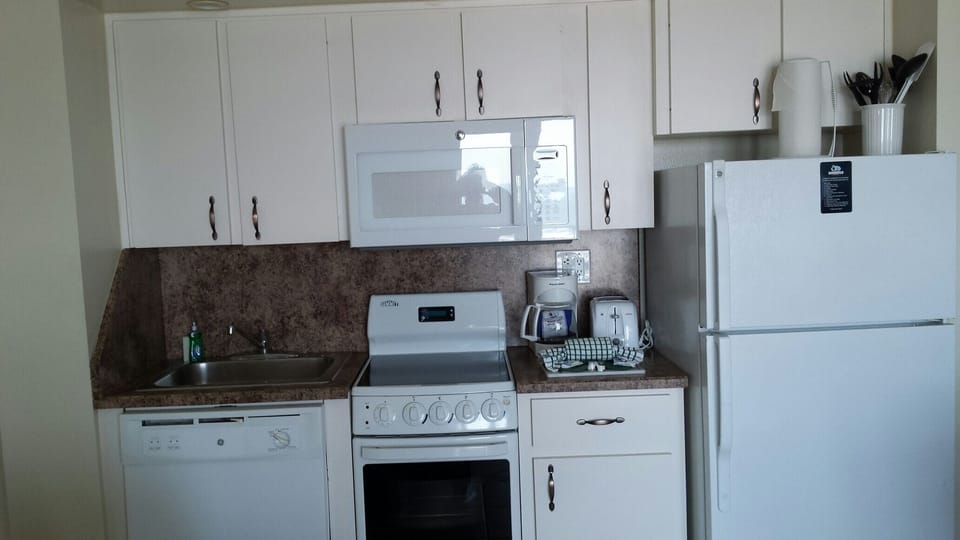 Full kitchen comes stocked with place settings, pots and pans, coffee pot...