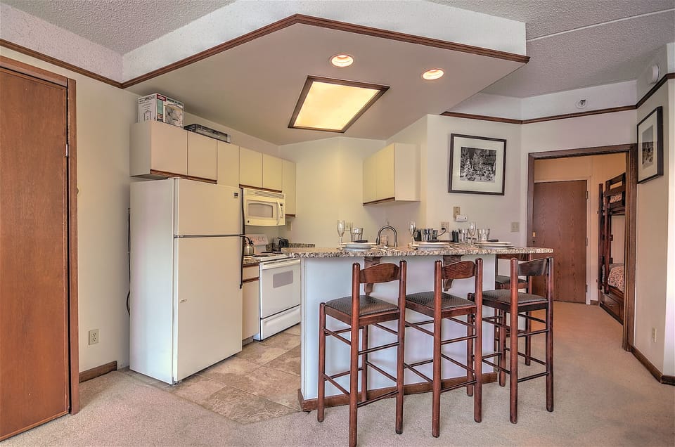 Kitchen with full-sized refrigerator, stove, oven, microwave and dishwasher.