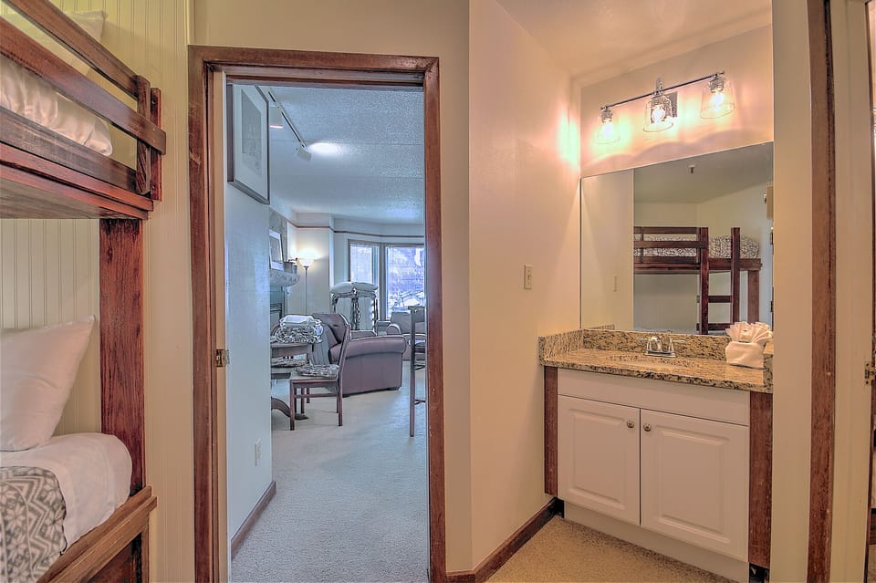 Custom bunk beds (L), pocket door for privacy and extra vanity granite top (R).