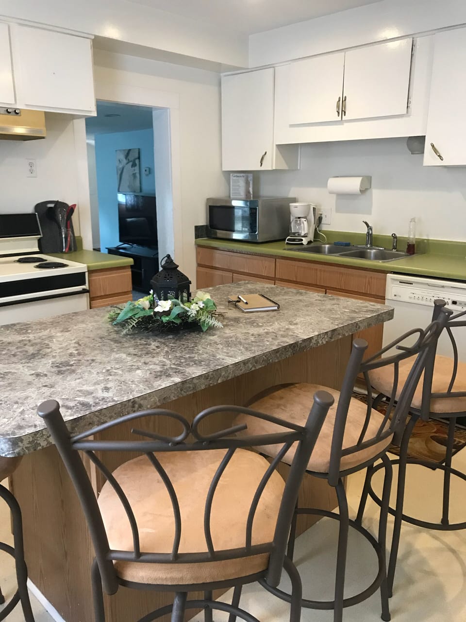 Full kitchen with stove, fridge, microwave, toaster and coffee pot.