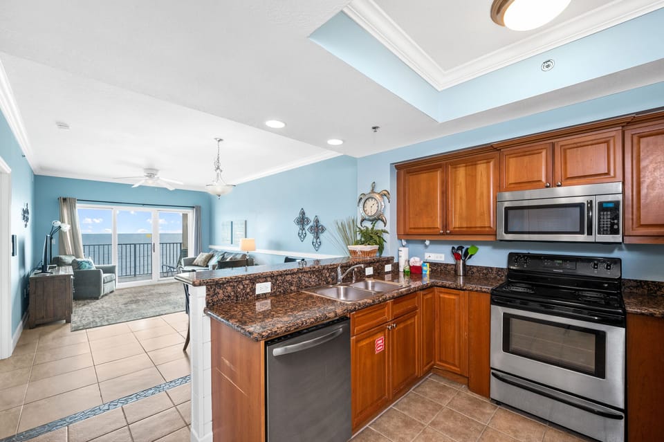 Completely furnished kitchen with dishwasher, range, microwave, and fridge.