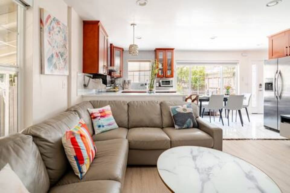 Living:Clean-lined leather sectional adds comfort& flexibility to the open space