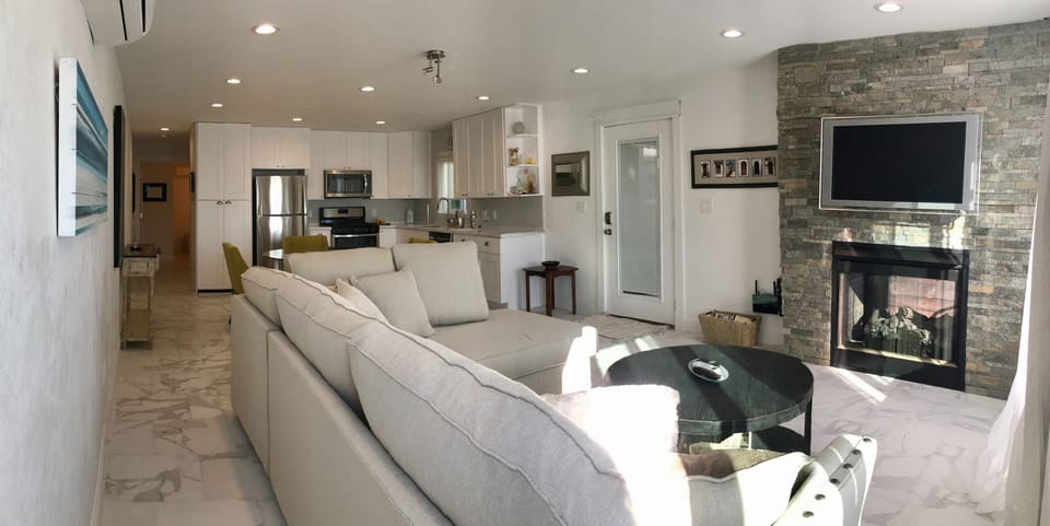 Living room with show stopping indoor/outdoor fireplace.