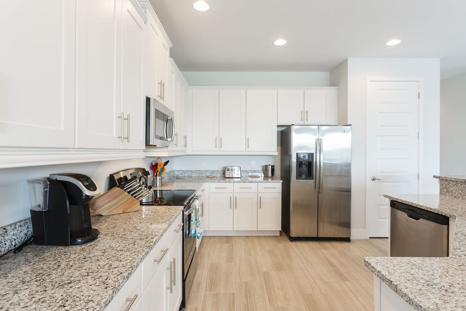 The fully equipped kitchen opens into the dining room with ample room on the granite counter tops to prepare a lavish gourmet meal