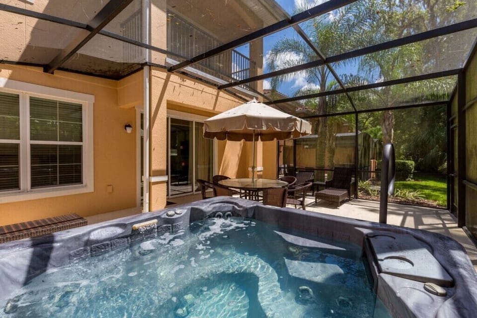Relax in the private outdoor hot tub under a screened patio for a peaceful retreat.