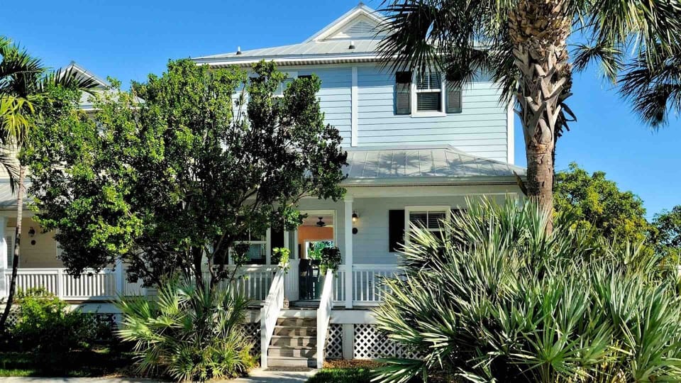 This large, freestanding home has a grassy lawn that surrounds the house front and back...