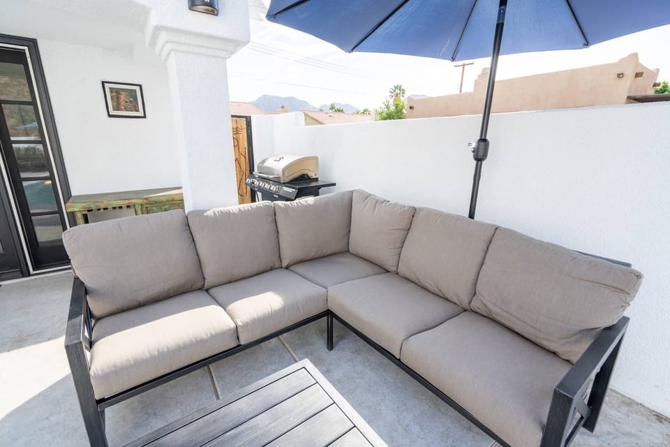 Comfortable seating with umbrella for relaxing by the pool