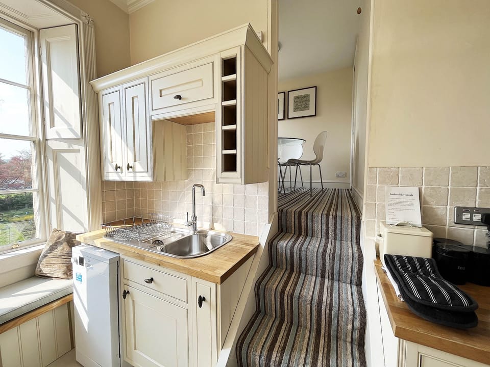 Stairs from galley kitchen leading to dining room area