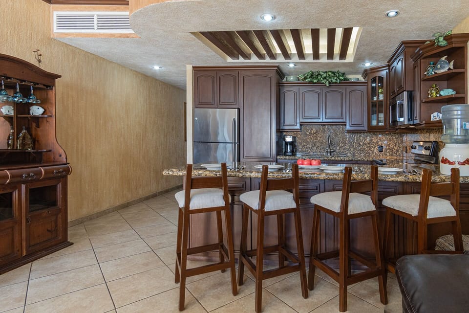 High backed stools line the kitchen counter.