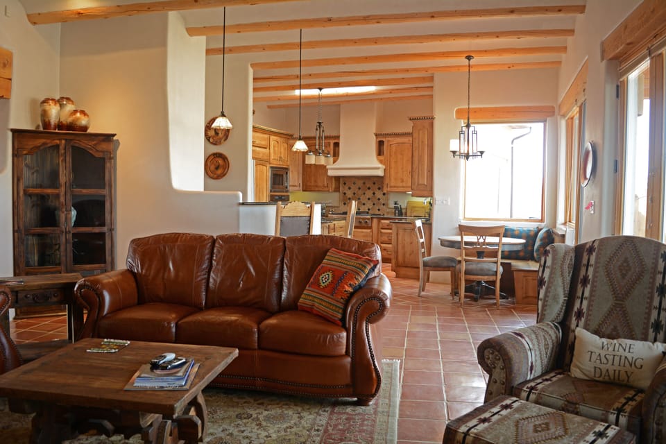 Open living room view to wet bar (center), breakfast round table (right) and into gourmet kitchen