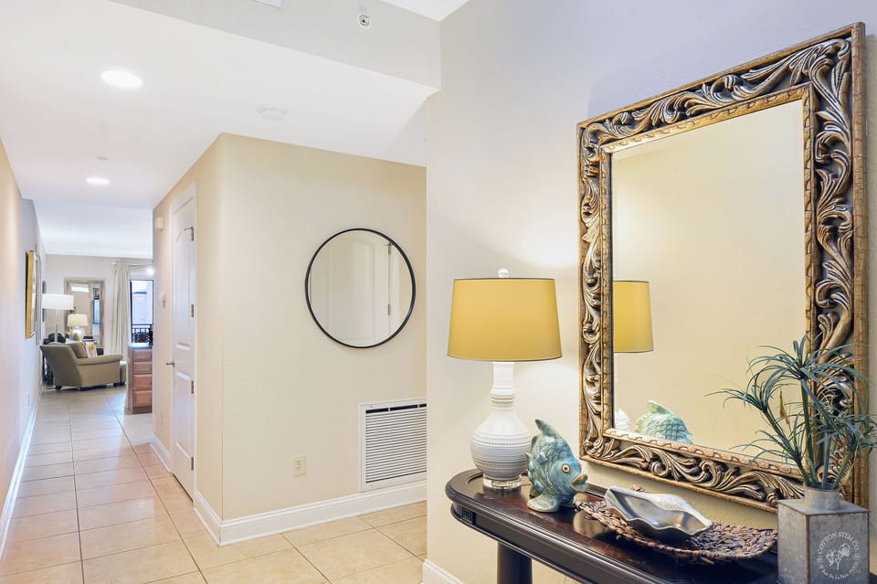 Entry Hall with Mirror and Bench - Entry hall with decorative mirror, bench, wall art, and direct access toward the main living area.