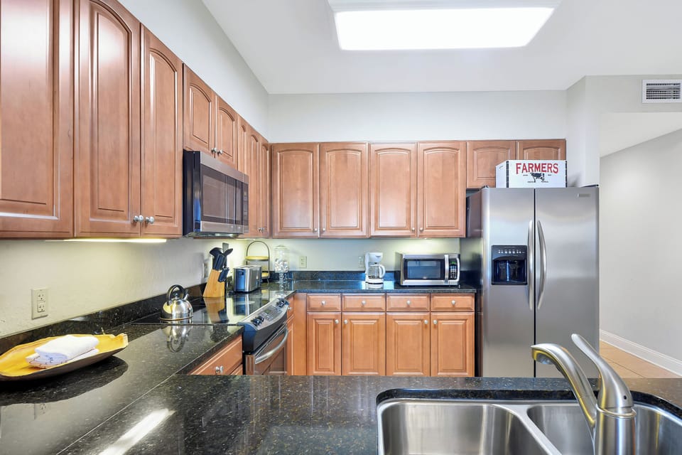 Kitchen Sink and Counter Space - Kitchen view with sink, granite counter space, stainless appliances, and open access to the dining area.