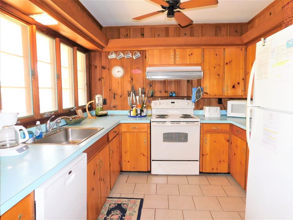 29554 N. Duneway - Cotton Patch East - Functional Kitchen - A traditional kitchen featuring wood cabinetry, white appliances, and ample counter space with a bright, open feel.