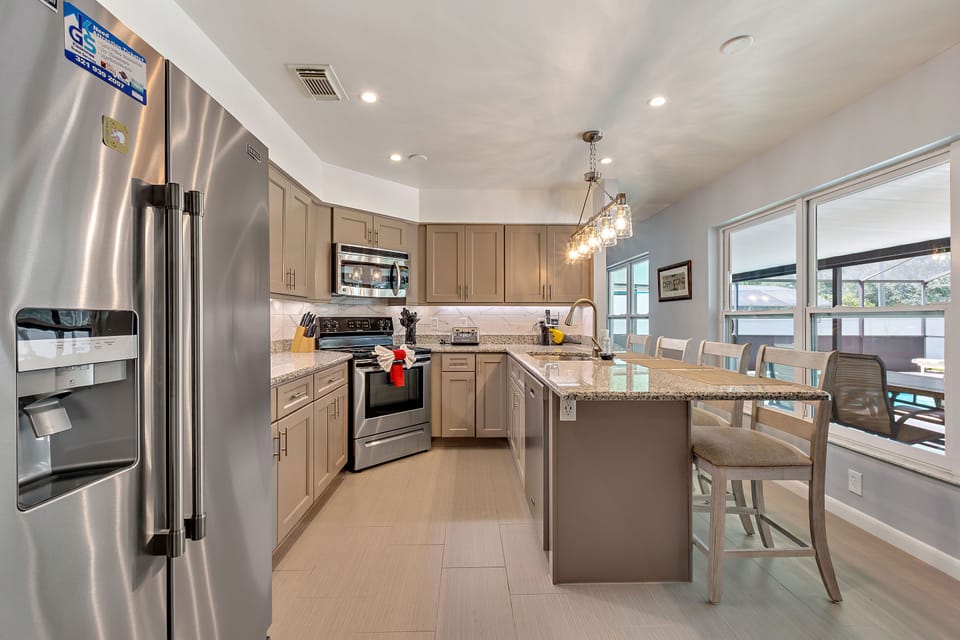 Fully equipped, stylish kitchen with sleek appliances and a breakfast bar for dining.