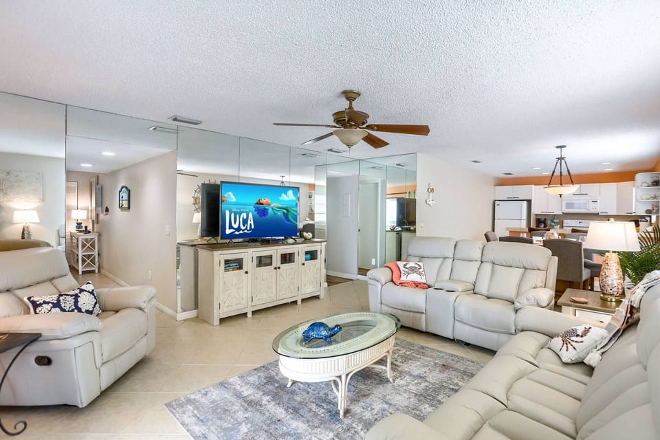 Living Room Offers a Leather Reclining Sofa, Loveseat, Armchair, and a Large Flat Screen TV