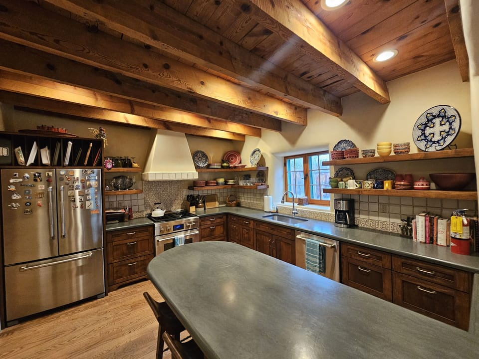 This well stocked kitchen has granite counter tops and overlooks the living room.