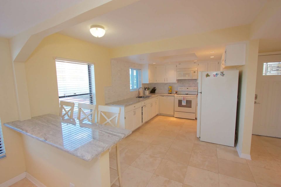 Entertain while packing a lunch for beach day or prepping a meal for the family in this beautifully updated kitchen with granite counter tops