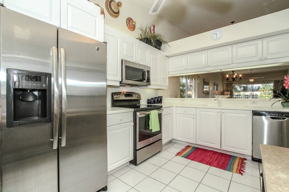 Raised panel cabinetry, solid surface counter tops, & stainless steel appliances in the kitchen.