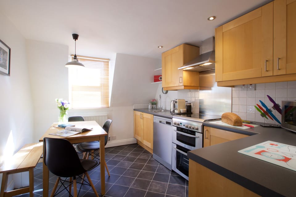 Kitchen with dining table set for five guests.