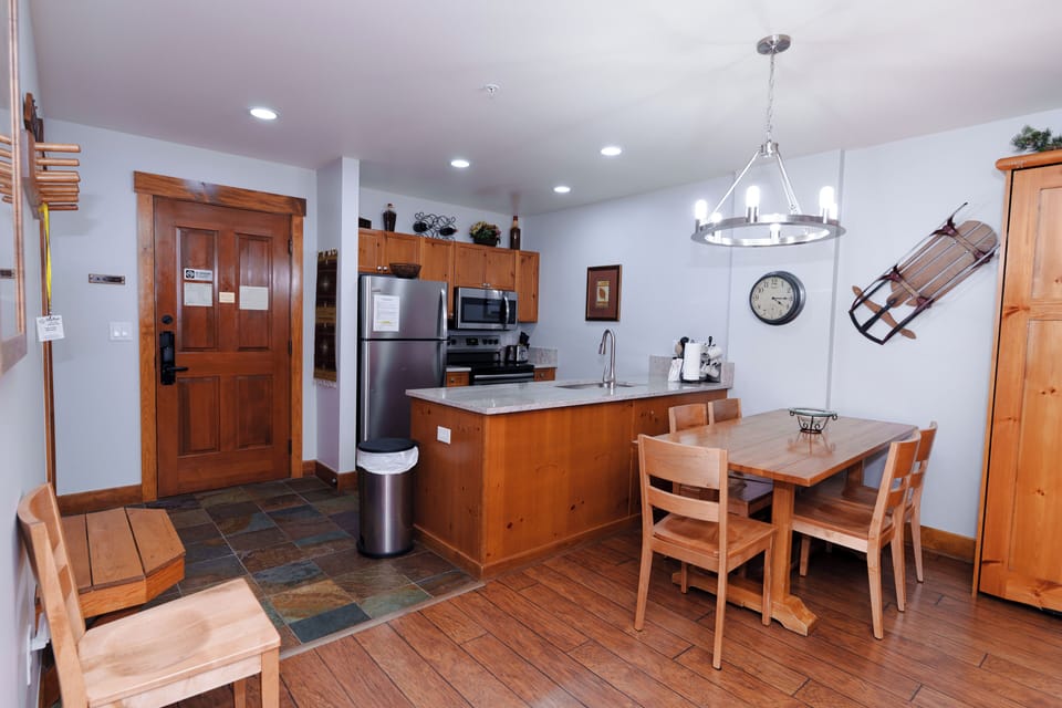Your fully equipped kitchen features modern appliances and a cozy dining area where you can prepare meals and gather with loved ones in mountain lodge style.
