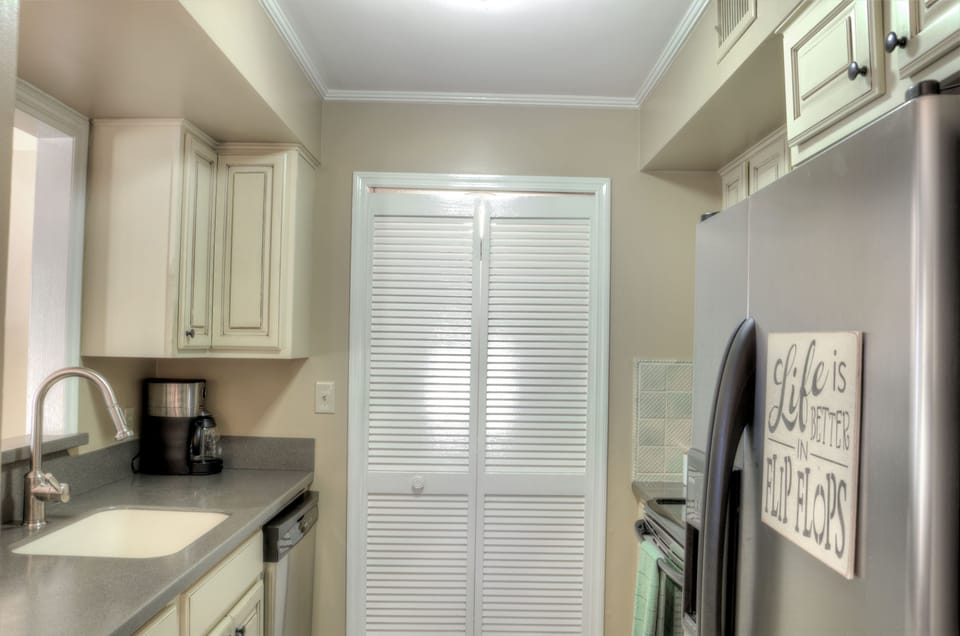 Kitchen Coffee Area - Kitchen angle with coffee maker, refrigerator, dishwasher, and cabinet storage.