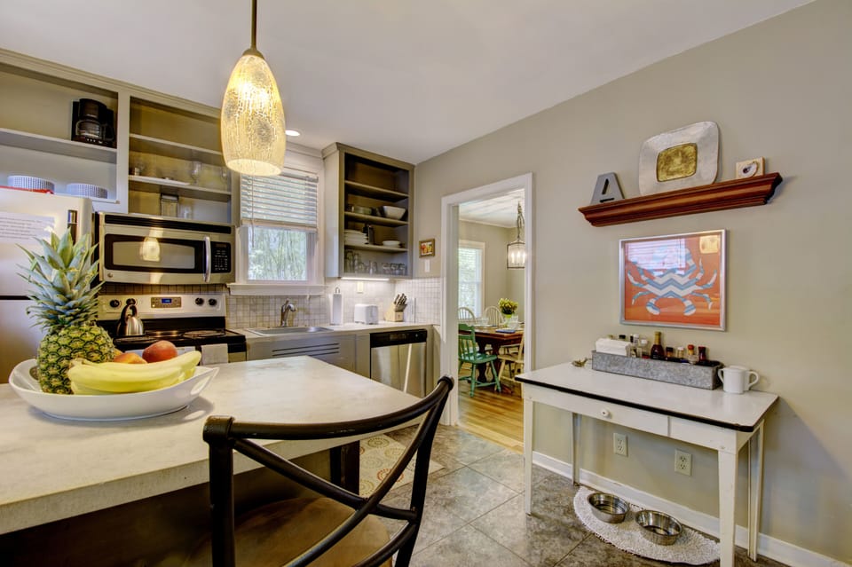 Eat-In Kitchen and Breakfast Bar - Second kitchen view shows the breakfast bar, sink, range, refrigerator, and door toward the porch and yard.