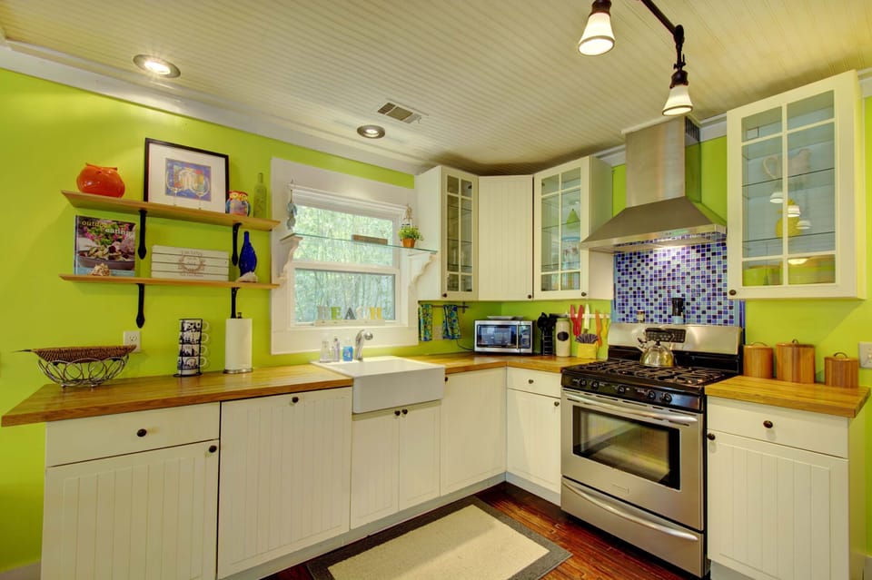 Bright Kitchen with Gas Range and Farmhouse Sink - Butcher block counters, open shelving, and a full kitchen setup keep meals easy between beach runs and dinner plans.