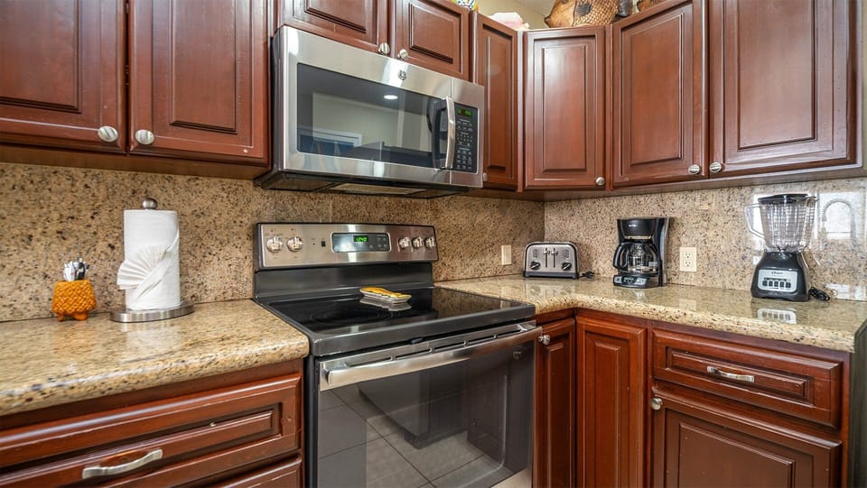 Step into this spacious and well-appointed kitchen, featuring an electric stove, modern appliances, and ample counter space—designed for both convenience and comfort, whether you're preparing a quick snack or a full meal.