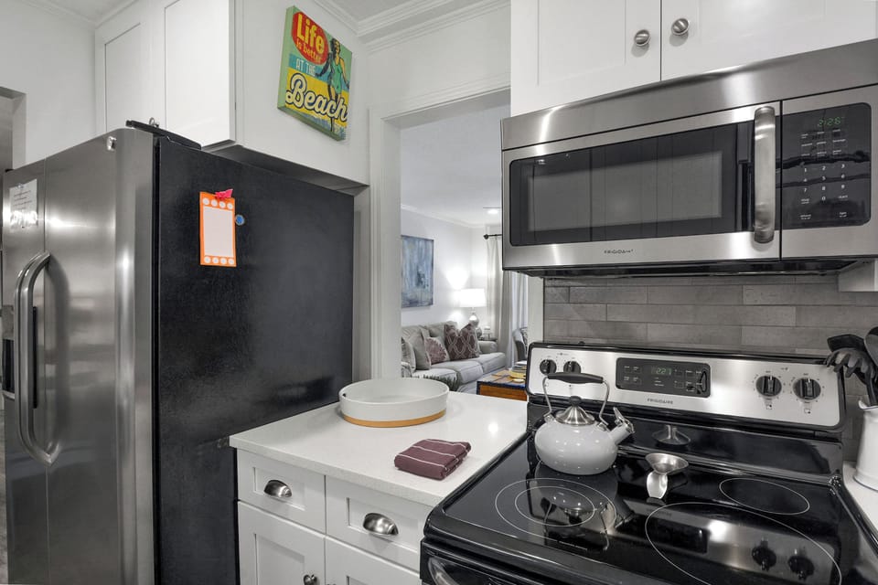 Kitchen Detail – Ocean Walk J-11 - From morning coffee to seafood suppers, this compact kitchen is equipped with stainless appliances and easy flow into the living space.