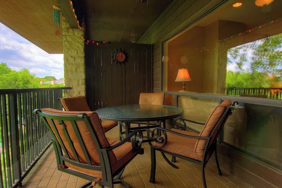 The patio is lit with festive lights, and the table seats four. 