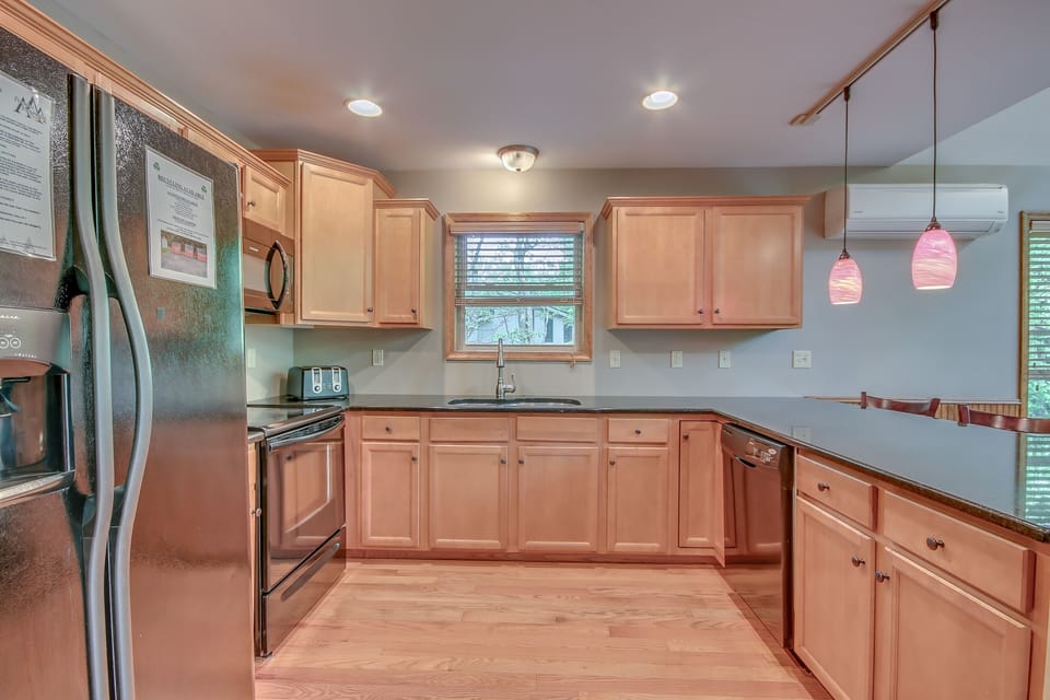 Kitchen interior featuring an island, sink and refrigerator