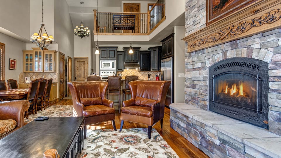 Relax in this cozy mountain retreat featuring a warm stone fireplace, plush seating, and rustic-chic decor. Enjoy a movie on the flat-screen or step onto the balcony for fresh air.