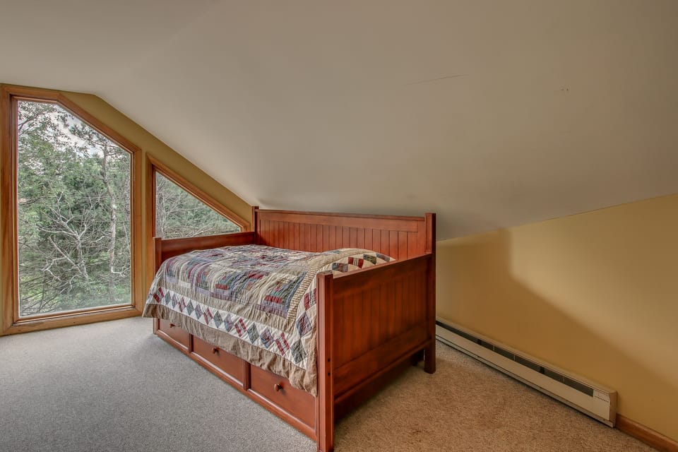 A small futon on the upper floor, by the window.