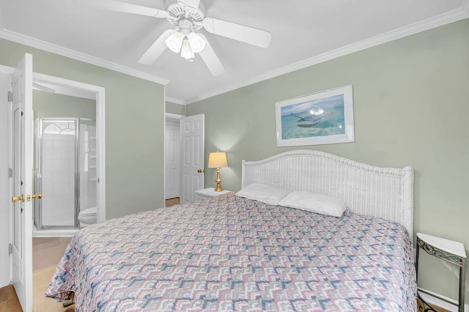 Unwind in your coastal-inspired bedroom, where soft sage walls and gentle ceiling fan breezes create a serene retreat. Sink into the plush bed after a day of adventure, and let the peaceful atmosphere lull you to sleep.