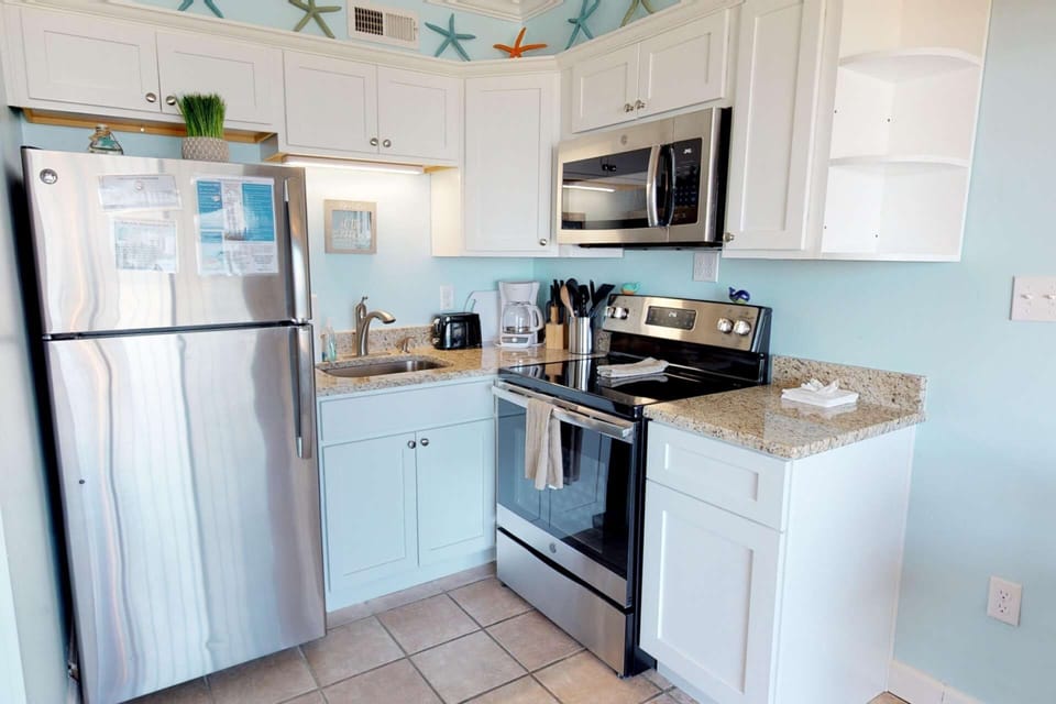 A well equipped kitchen with a full size fridge, microwave, oven, stovetop, coffee maker, and many cooking tools to make your own meals.