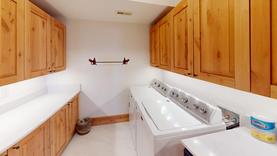 Your own dedicated laundry room with rustic wood cabinets and full-size washer and dryer keeps your vacation wardrobe fresh.