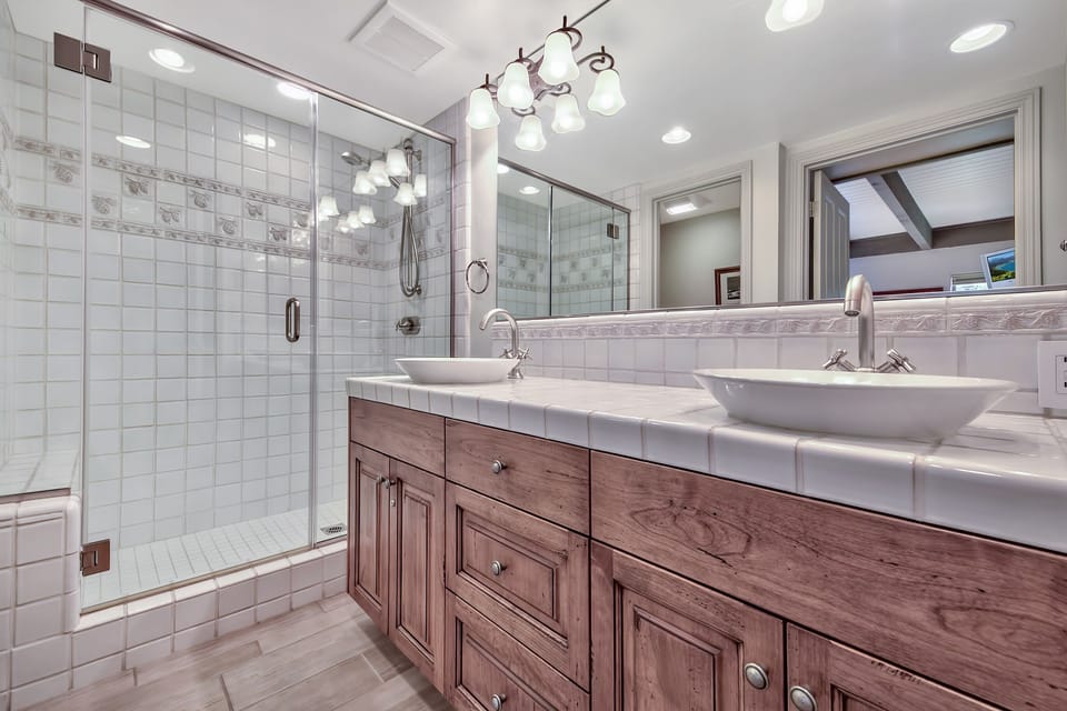 Indulge in this spa-like bathroom with dual vessel sinks, elegant lighting, and a spacious glass shower where you can unwind after your adventures.