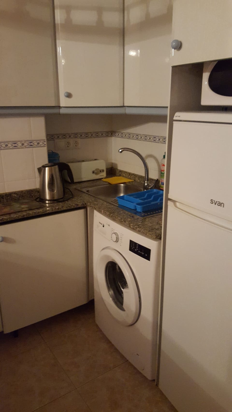 The kitchen with fridge freezer, microwave, toaster and cooker.
