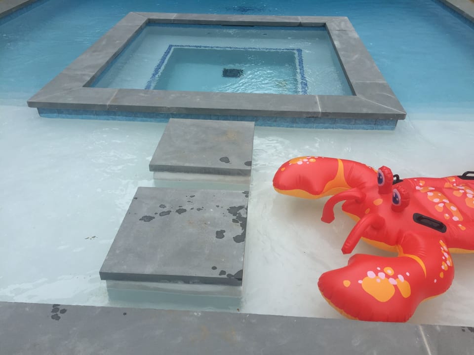 Close-up of heated pool's huge sun deck (20 feet wide) & large interior hot tub