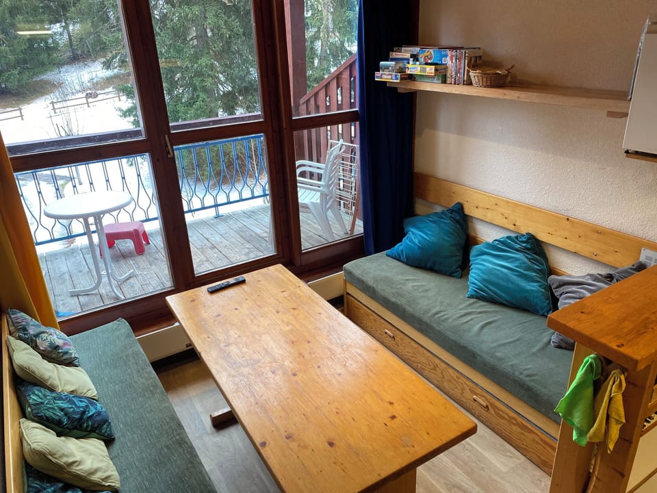 Living room - table with 3 stools and seating from sofa on left, sofa bed right.