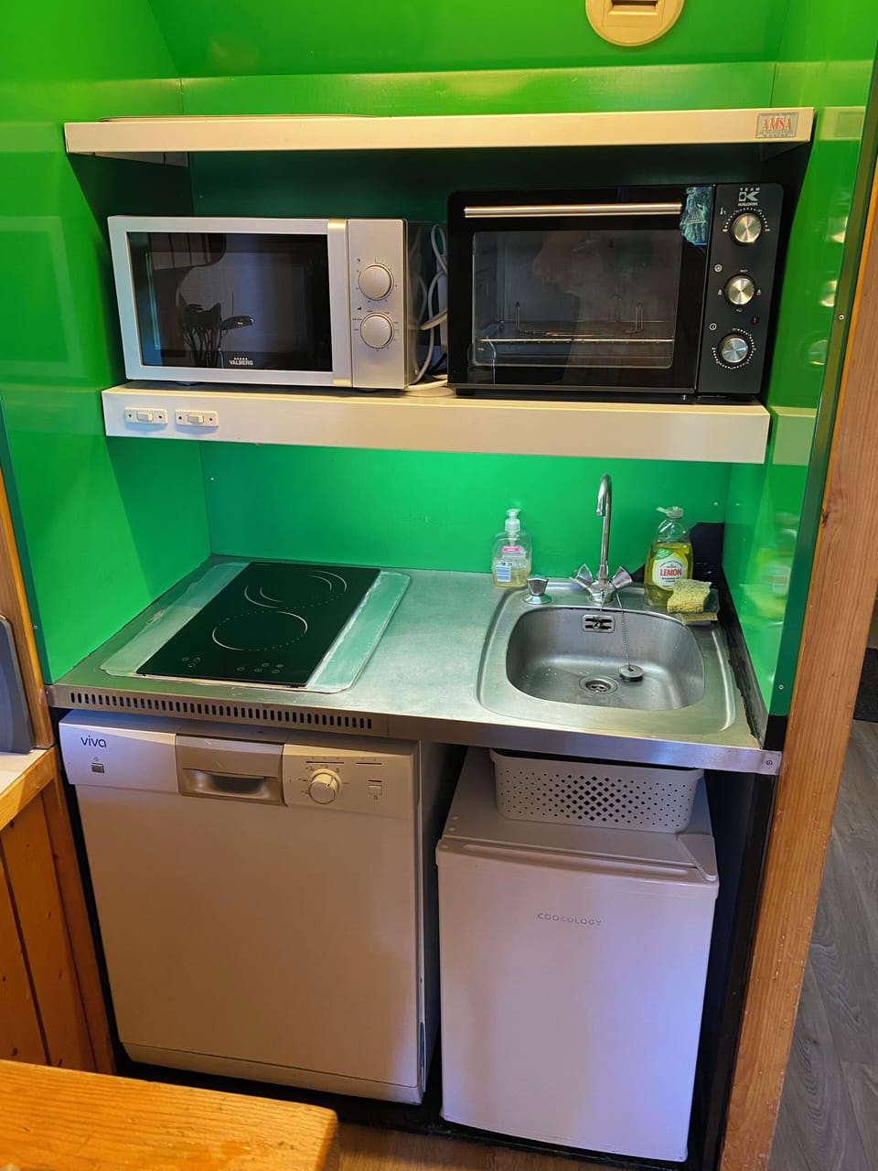 Kitchen showing 2 burner hob, sink, electric oven, microwave and fridge freeze.